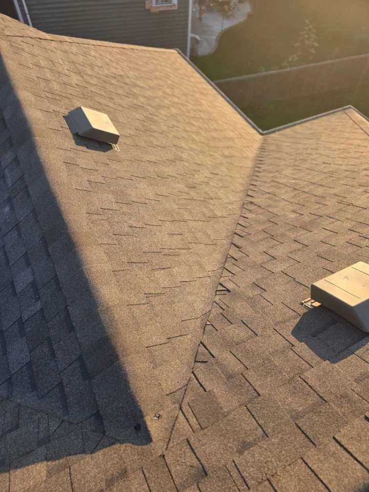 Roofing technician installing asphalt shingles on a residential roof